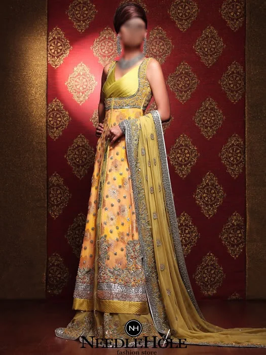 Glamorous Pakistani bridal gown dress in yellow-orange and gold color. Deep V-neck embellished bodice front slit fully embellished wedding gown comes Glamorous Pakistani bridal gown dress in yellow-orange and gold color. Deep V-neck embellished bodice front slit fully embellished wedding gown comes