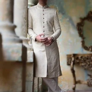 Jamawar men sherwani for groom wedding in ivory color and with gold buttons, comes with kurta pajama in offwhite color