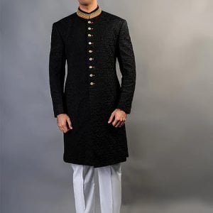 Fully embroidered sherwani for groom in black raw silk fabric, features embroidery on collar and gold fancy buttons with red contrast buttonholes, comes with offwhite kurta pajama